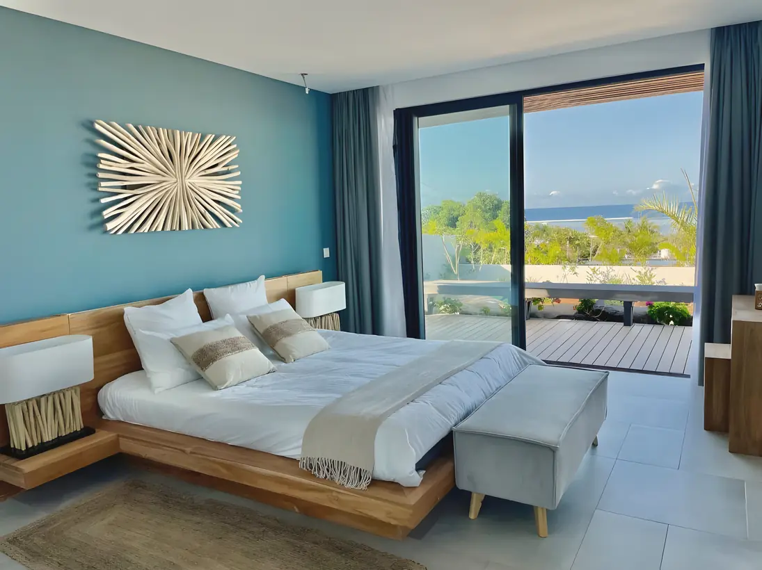 A bedroom opening to a private deck and the sea